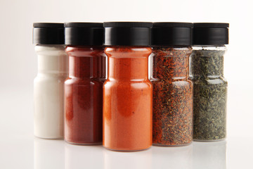 Various spices in small glass bottles, close up
