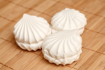 Three white sweet airy zephyrs on bamboo napkin