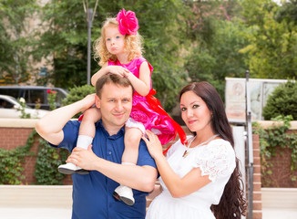 Happy family of father, pregnant mother and child in outdoor on a summer day. Portrait parents and kid on nature. Positive human emotions, feelings, joy.