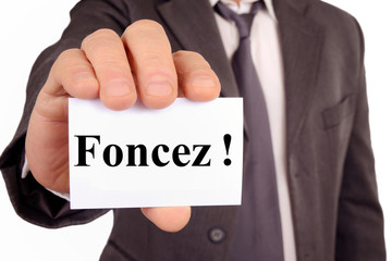 Homme montrant une carte avec écrit foncez dessus