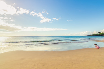 Young photographer taking pictures of sunset on the beach