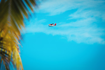 Sea plane flying on sky in Maldives