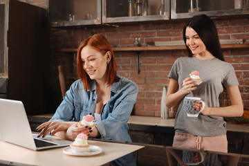 Attractive young females looking at the laptop