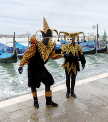 Fototapeta na wymiar VENICE, ITALY - MAR 04, 2014: Unrecognizable persons wearing carnival costume (mask) in Saint Mark square in Venice, Italy. In 2014 the Carnevale di Venezia was held between 15 Feb - 04 Mar