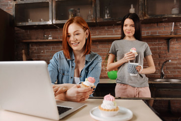 Delighted young females eating desserts