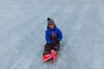 Fototapeta na wymiar happy little boy learning to skate in winter