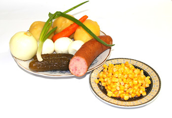 Овощи. Это овощи, приготовленные для салата:картофель, морковь, огурцы, кукуруза. Кроме овощей ещё имеется яйца и колбаса.