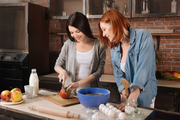 Attractive brunette use knife while cutting apple