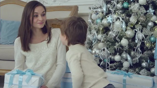 Young mother and her happy son beig excited about his Christmas present