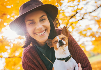 happy young woman with dog outdoors in autumn