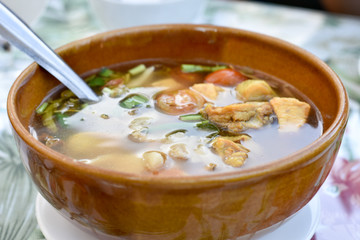 Hot soup with fresh green peas and herbs
