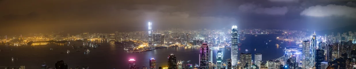 Foto op Aluminium Hong Kong, China skyline panorama vanaf de overkant van Victoria Harbour. Hong Kong skyline van de stad uitzicht vanaf de haven met wolkenkrabbers gebouwen weerspiegelen in water bij zonsondergang © JONGSUN BAEK
