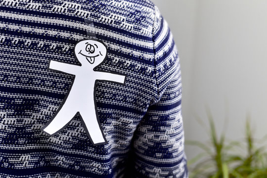young man with a paper man attached to his back