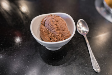 Scoop of Chocolate ice cream in white bowl on black table with copy space.
Chocolate Ice Cream Scoop From Top.