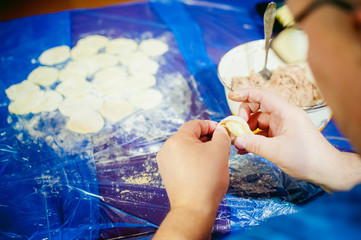 hand modeling dumplings at home in the kitchen.