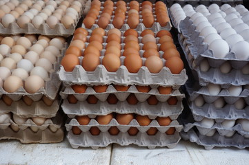 Giant cardboard crates of fresh white, yellow and brown eggs at the market