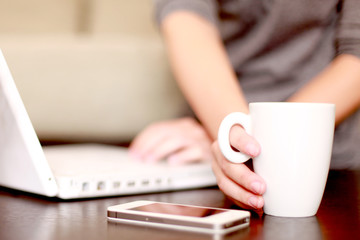 Fototapeta premium Computer, Handy und Tasse auf dem Tisch