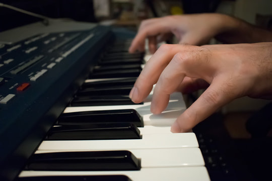 Man hands on the keyboard of the piano
