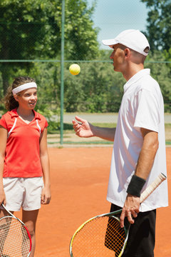 Tennis training. Tennis instructor and teenage student