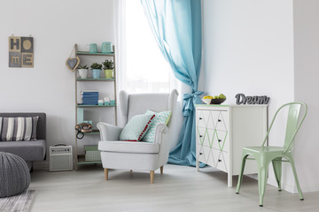 Living room with mint chair and white armchair
