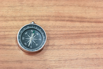 Simple compass on the wooden table with copy space
