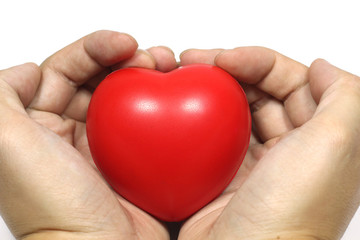 Fototapeta premium Bliska ręka trzyma czerwone serce gąbki, symbol miłości na białym tle