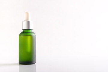 Green essential oil bottle on white background.