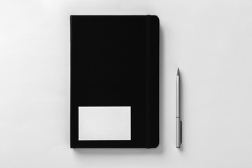 Mockup of business card on notepad cover at white textured paper