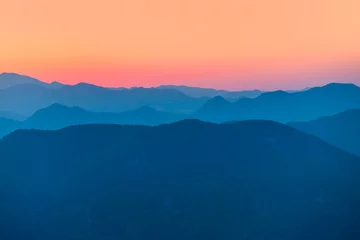 Foto op Canvas Landschap met blauwe bergen bij zonsondergang © muratart