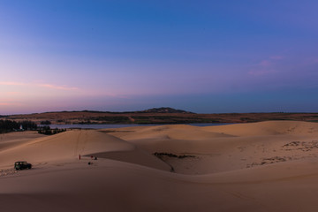 Fototapeta na wymiar Sunrise at the white sand dunes in Mui Ne, Vietnam