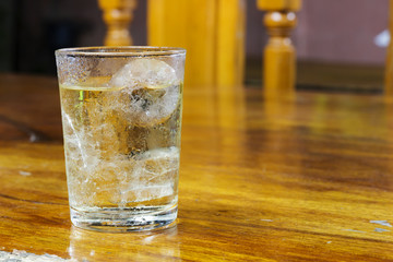 Drinking water in the glass on a wooden table.
