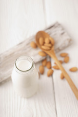 Almond milk in a glass bottle and almond nuts