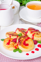 Sweet cottage cheese pancakes and raspberry sauce. Traditional Russian and Ukrainian dish for breakfast.