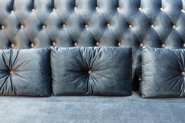 Close up of blue velvet sofa and cushions with vintage style