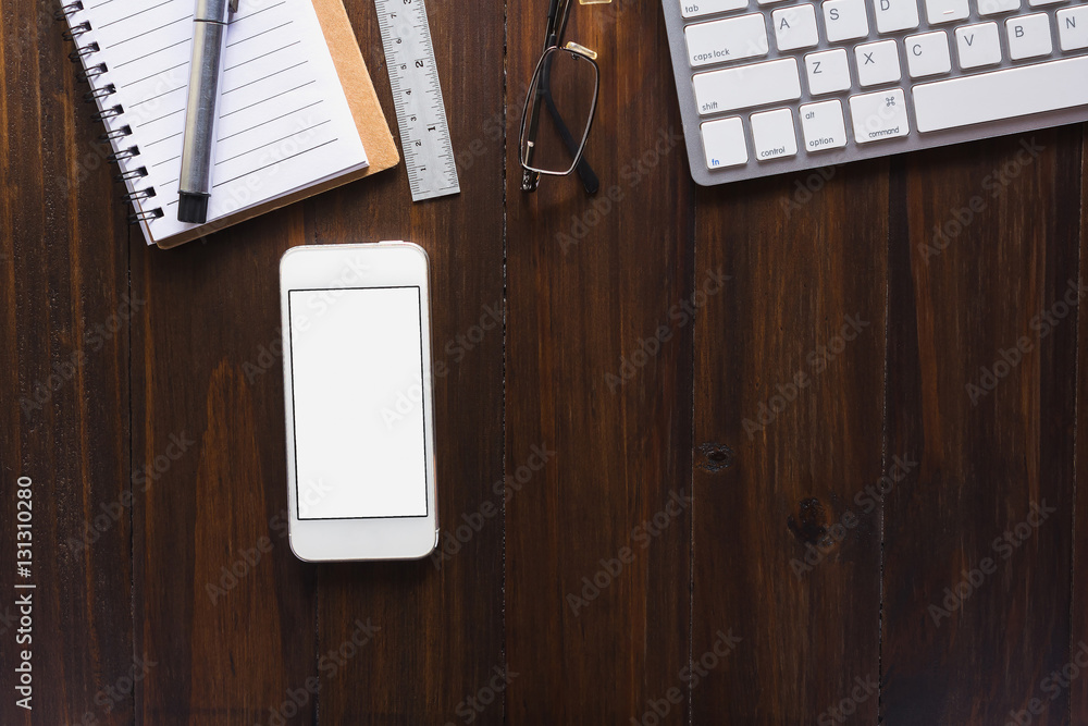 Wall mural office workspace with keyboard notepad and smartphone on wood table.