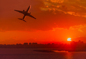 Fototapeta na wymiar Passenger plane is landing away from airport at sunset