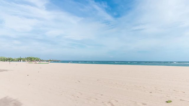 Moving panorama of the beach Nusa Dua, Bali, Indonesia, Asia. Tropical scene, beautiful sky, surfers, beach. Sunny day.