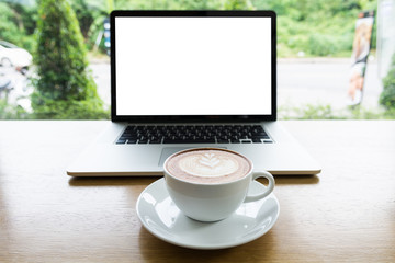 Working with laptop and latte art coffee on table
