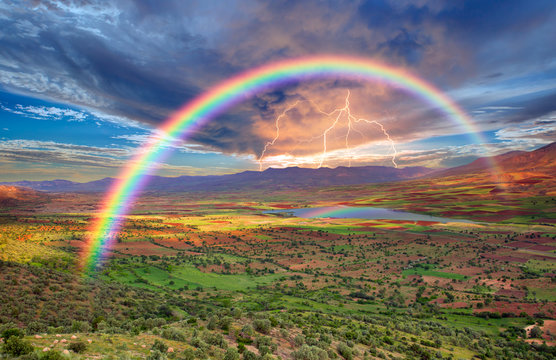 Rainbow Over The Valley With Lightning