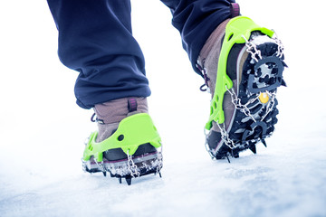 Hiking boots with equipment for ice. Snow like a background and sun. Sun is shining. Moutains and travel.  - 131313820