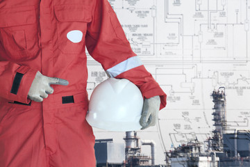 Engineer holding safery hetmet on refinery background