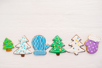 Celebrating New Year at home. Christmas ginger and honey cookies on white wooden background. Fir tree, glove shape. Festive bakery top view, flat lay. Gingerbread with copy space.