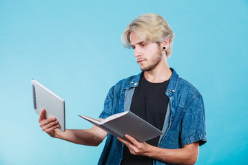 Man student holding tablet and book.