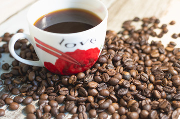 Кофейные зерна и чашка сваренного кофе.