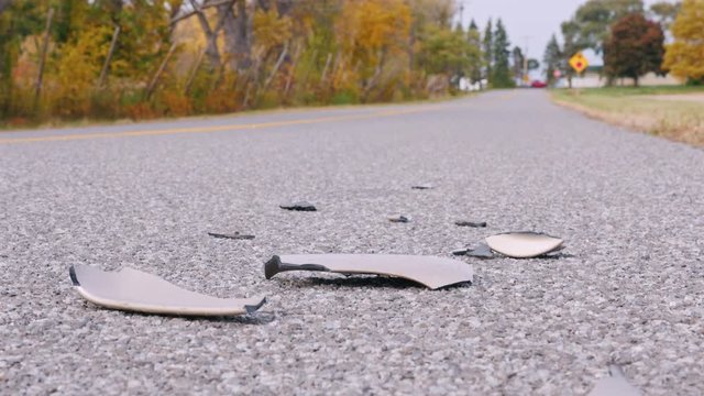 Traces of a car accident. Vehicle bumper pieces lie on the road