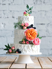 White wedding cake with flowers and blueberries