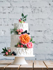 Fototapeta na wymiar White wedding cake with flowers and blueberries