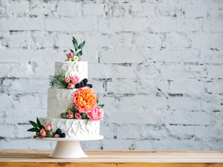 White wedding cake with flowers and blueberries