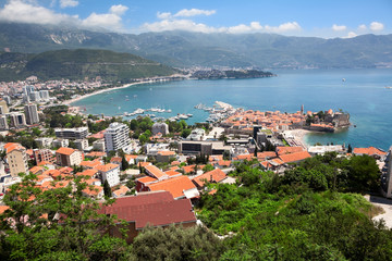 Naklejka na ściany i meble Aerial view at the Budva city with modern buildings, sea port and walled fortress. Montenegro, Europe