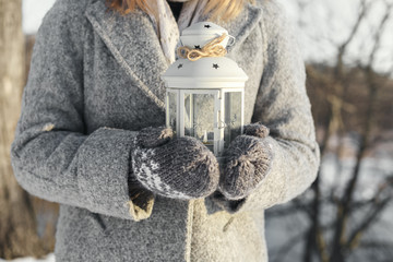 girl holding lantern with a burning candle inside